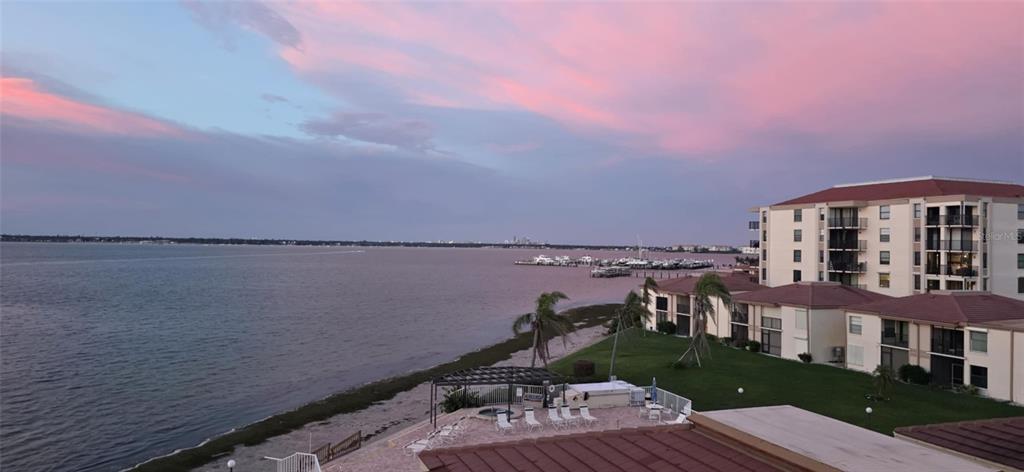 An elevated view of a waterfront apartment complex with a pool deck and boat docks — 6177 SUN BOULEVARD UNIT 401, ST PETERSBURG, FL