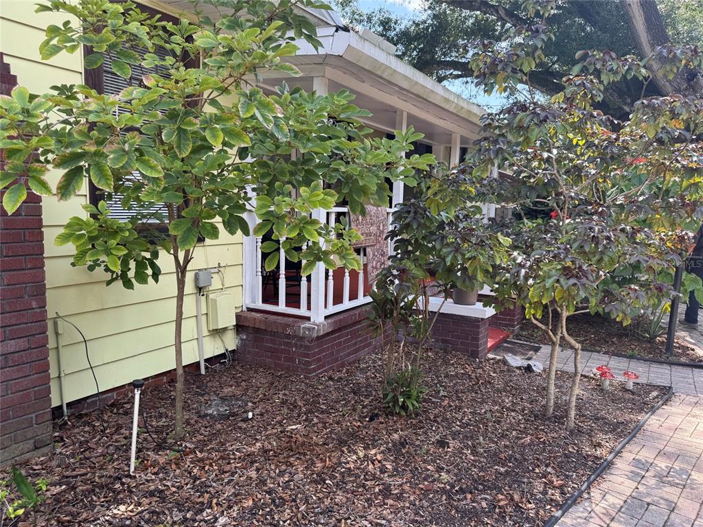 A yellow house with a brick foundation and a small front porch with white railings — 6408 N HIGHLAND AVENUE, TAMPA, FL
