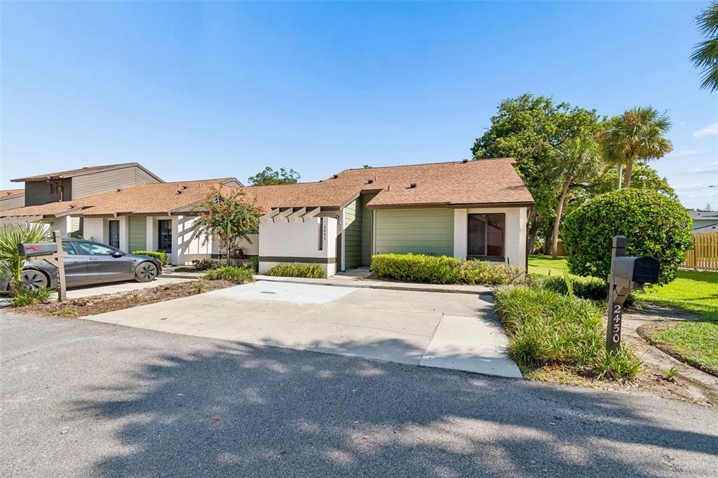 A single-story residential building with a concrete driveway and a mailbox in the foreground — 2450 GRAND TETON CIRCLE UNIT 2450, WINTER PARK, FL