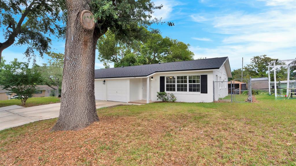 A white single-story house with a black roof, a garage, and a large front tree — 134 JEWEL DRIVE, ALTAMONTE SPRINGS, FL