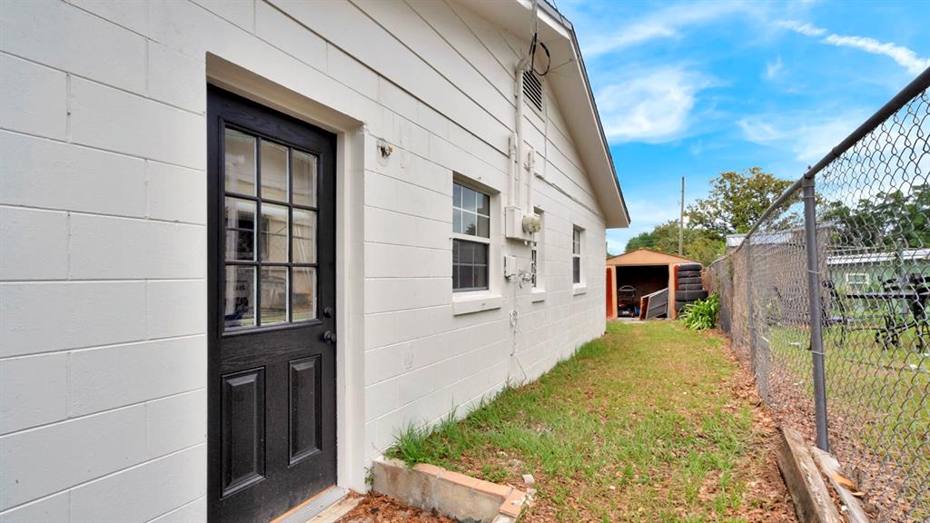 The exterior of a white concrete block building features a black door and two windows — 134 JEWEL DRIVE, ALTAMONTE SPRINGS, FL