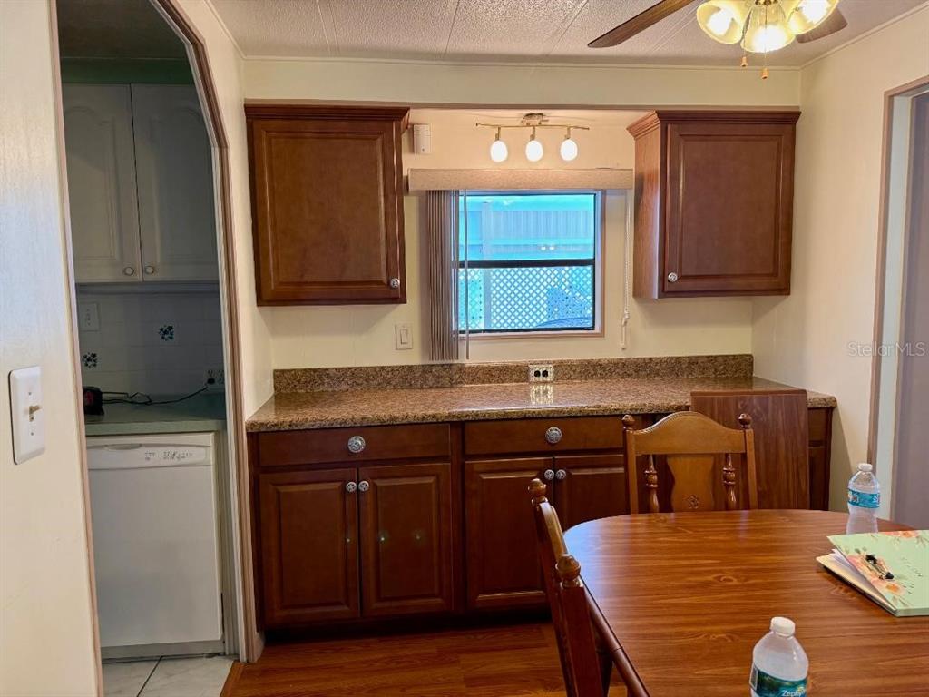A kitchen features dark wood cabinets, granite countertops, and a dining table in the foreground — 8144 RIDGE DALE AVENUE, BROOKSVILLE, FL
