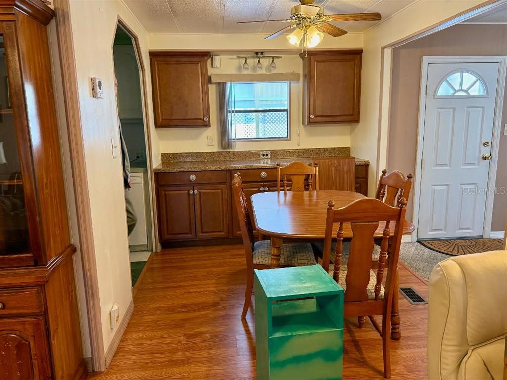 A dining area features wood cabinets, a wooden table with chairs, and a ceiling fan — 8144 RIDGE DALE AVENUE, BROOKSVILLE, FL