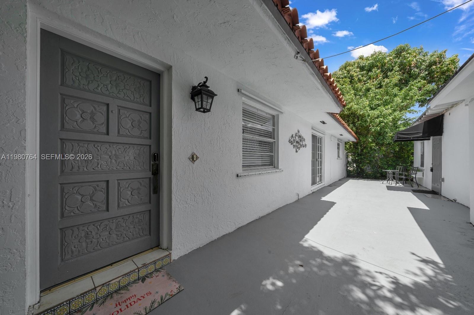 A gray front door with decorative panels opens onto a concrete patio area — 1044 SW 13th Ct # 2, Miami FL 33135, MIAMI, FL