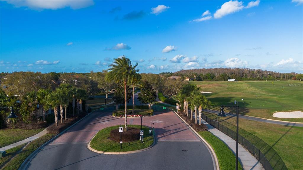 An aerial view shows a gated entrance with a roundabout leading to a golf course — 13060 HATHERTON CIRCLE, ORLANDO, FL