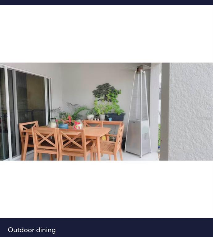 An outdoor patio features a wooden dining set, potted plants, and a tall metal heater — 440 TISONE LANE, DAVENPORT, FL