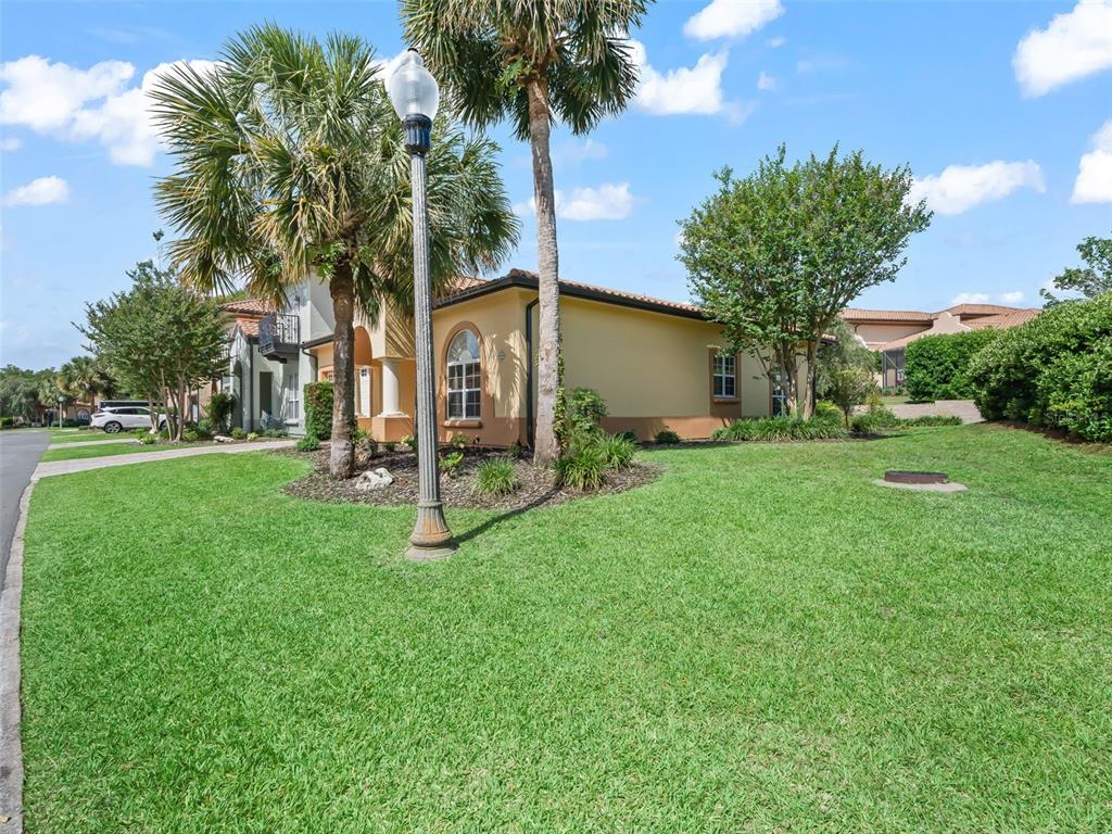A yellow stucco house exterior with a palm tree and a street lamp in front — 1256 AVENIDA DE LAS CASAS, LADY LAKE, FL