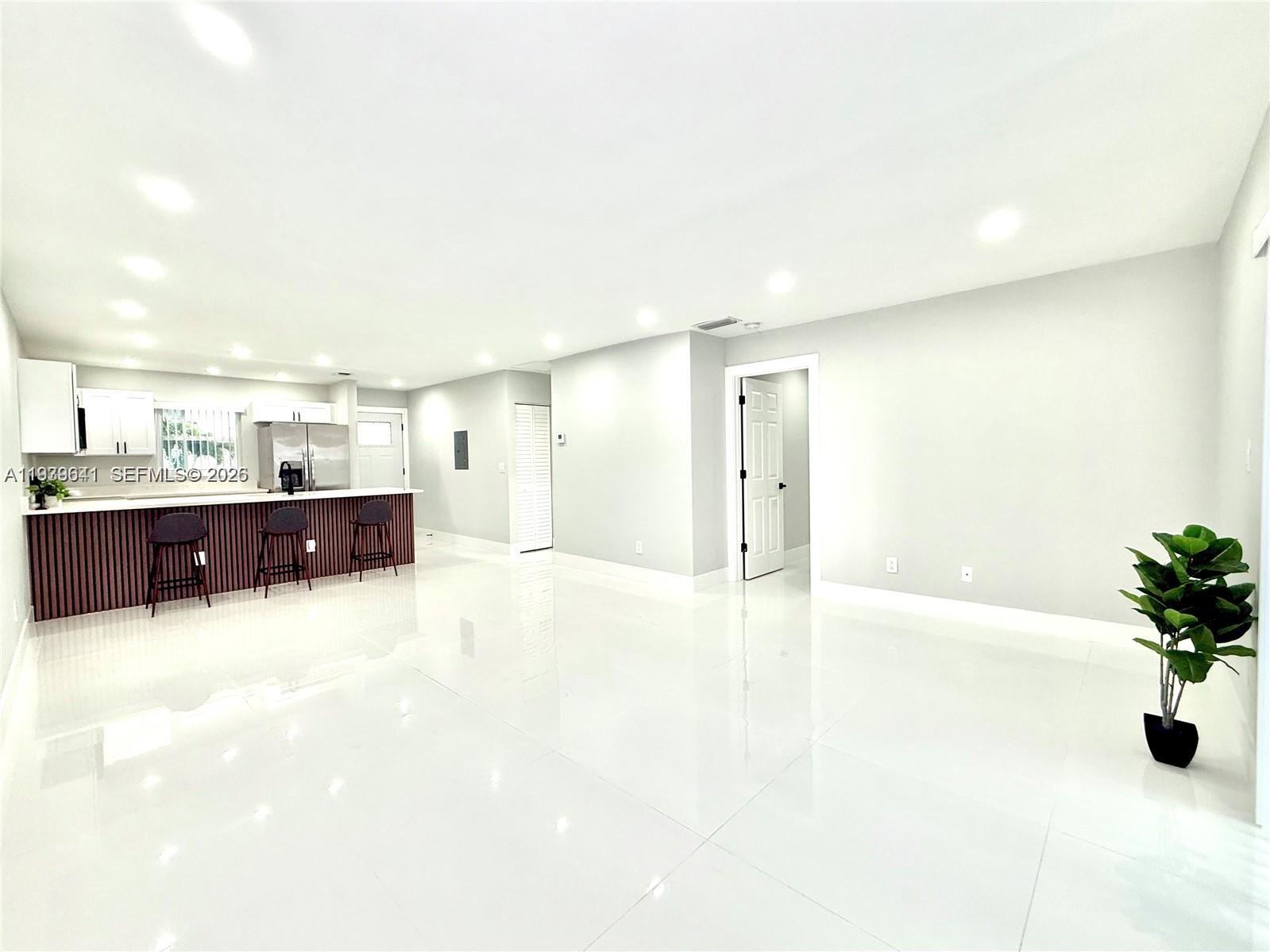 A bright, open-concept living area features white tile floors, recessed lighting, and a kitchen island — 11240 SW 33rd Cir Pl, Miami FL 33165, MIAMI, FL