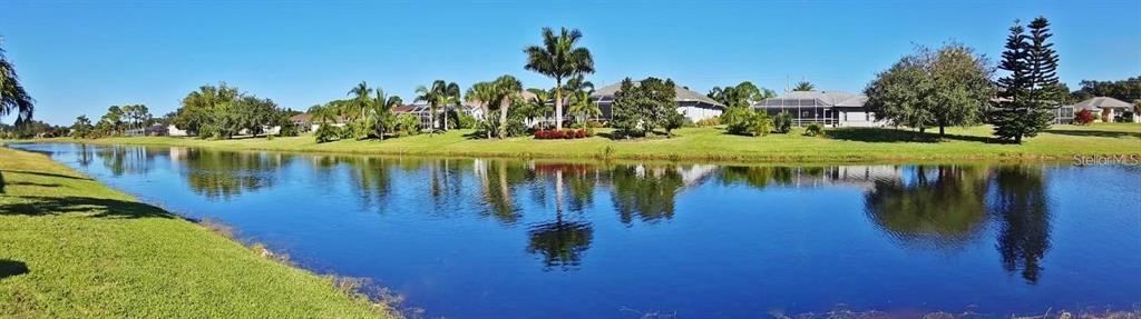 A panoramic view of a calm canal bordered by grassy lawns and residential houses — 847 ROTONDA CIRCLE, ROTONDA WEST, FL