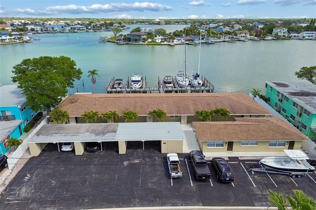 An aerial view shows a waterfront apartment building with a parking lot and boat slips — 2307 BAY BOULEVARD, INDIAN ROCKS BEACH, FL