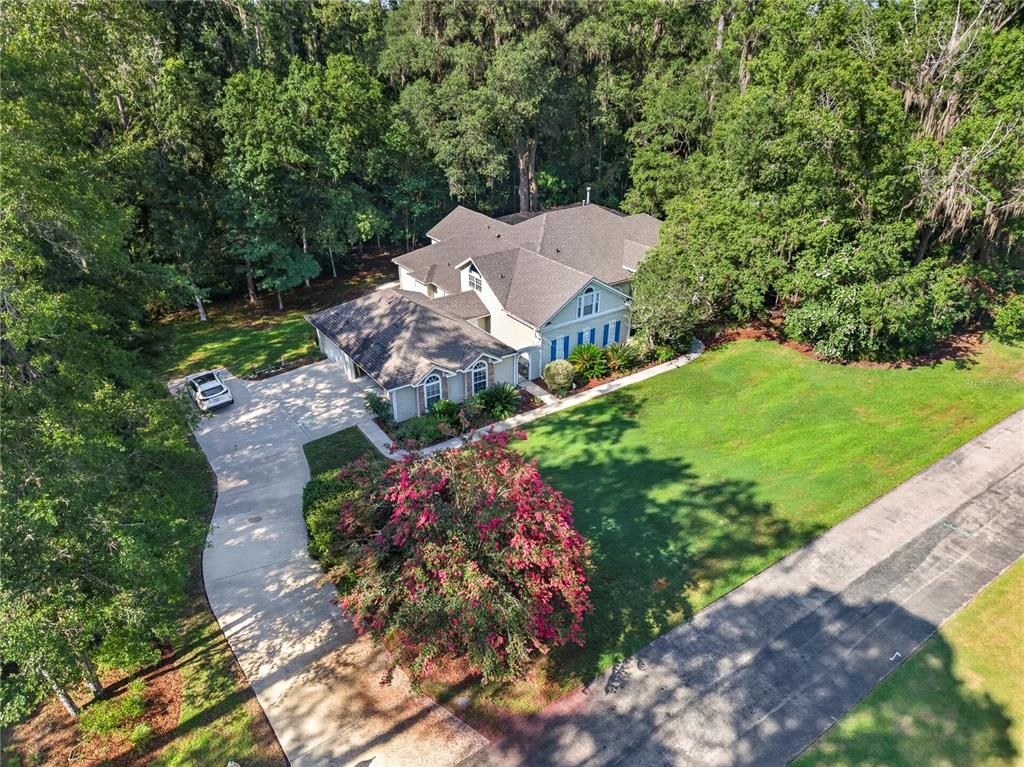 An aerial view shows a house with a driveway, a large lawn, and surrounding trees — 11415 NW 10TH LANE, GAINESVILLE, FL