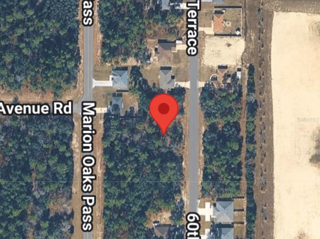 This is a satellite map view showing a vacant lot marked with a red pin — 14214 SW 60TH TERRACE, OCALA, FL
