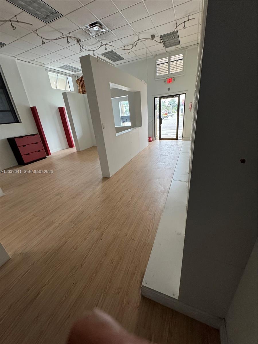 This commercial space features light wood-look flooring, white partition walls, and a glass entry door — 2 S Federal Hwy, Dania Beach FL 33004, DANIA BEACH, FL