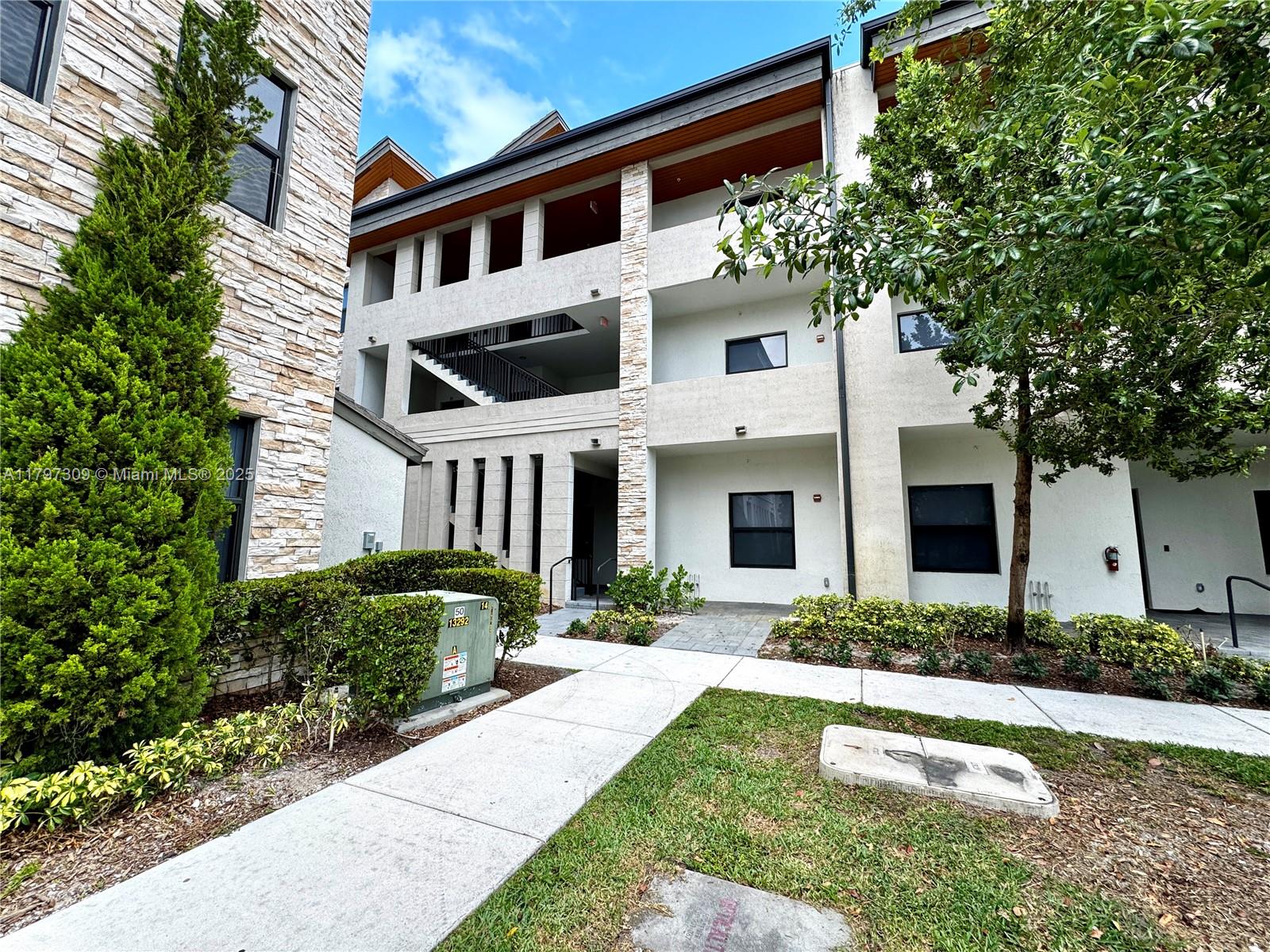 A multi-story apartment building features stone veneer, stucco walls, and an outdoor staircase — 8175 NW 104th Ave # 21, Doral FL 33178, DORAL, FL