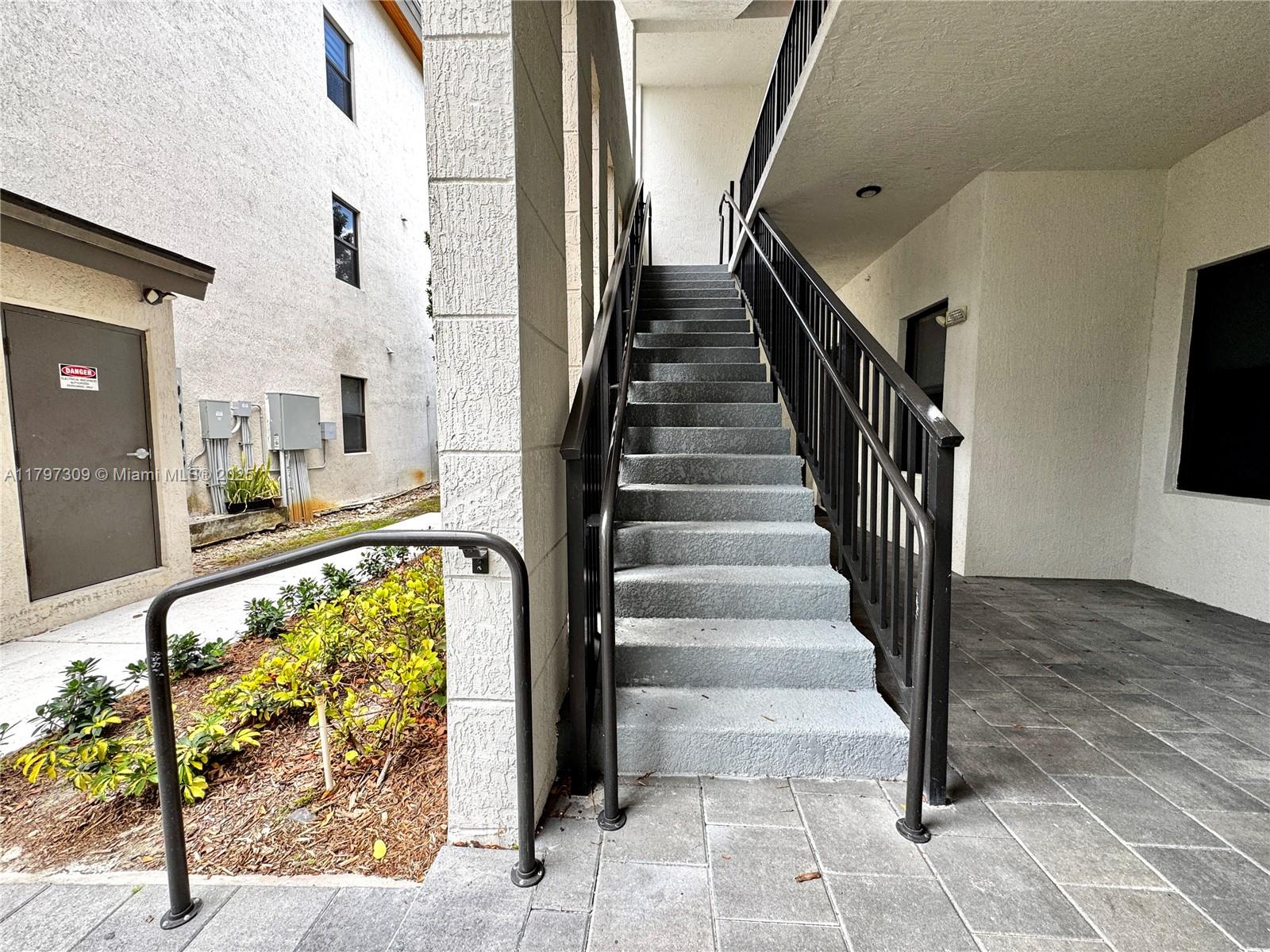 An outdoor staircase with black metal railings leads to an upper level of a building — 8175 NW 104th Ave # 21, Doral FL 33178, DORAL, FL