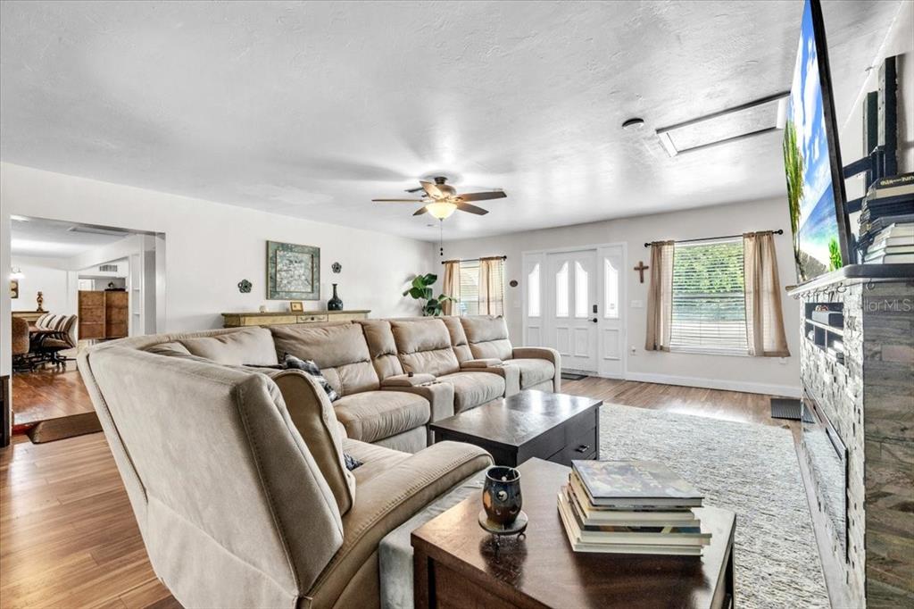 A living room features a large sectional sofa, a coffee table, and a wall-mounted television — 1655 DANIELS DRIVE, NORTH FORT MYERS, FL