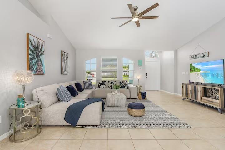 A living room features a large sectional sofa, a patterned area rug, and a television — 2705 SW 11TH PLACE, CAPE CORAL, FL