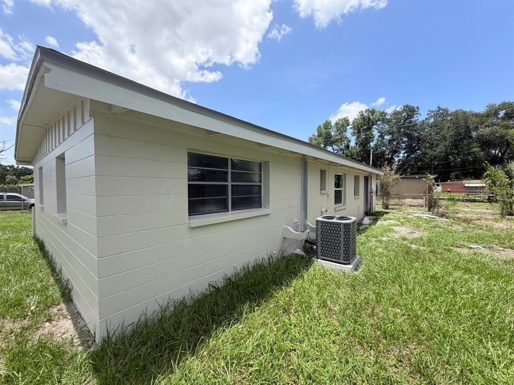 A side view of a light-colored house with a central air conditioning unit — 1310 WARRINGTON WAY, TAMPA, FL