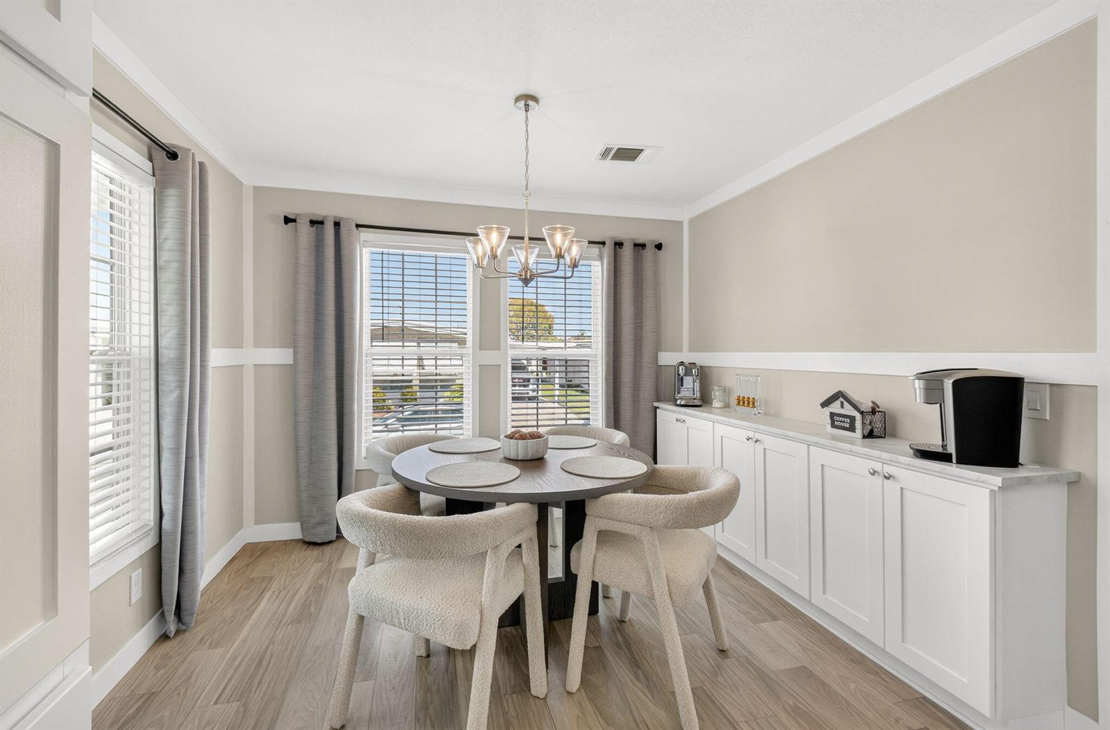 A dining room features a round table, four cream chairs, and white built-in cabinets — 58012 Bahama Bay, Boynton Beach FL 33436, BOYNTON BEACH, FL
