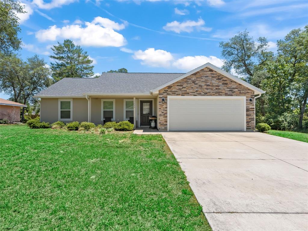 A single-story house with a stone-accented facade, a two-car garage, and a concrete driveway — 13645 SW 39TH COURT, OCALA, FL