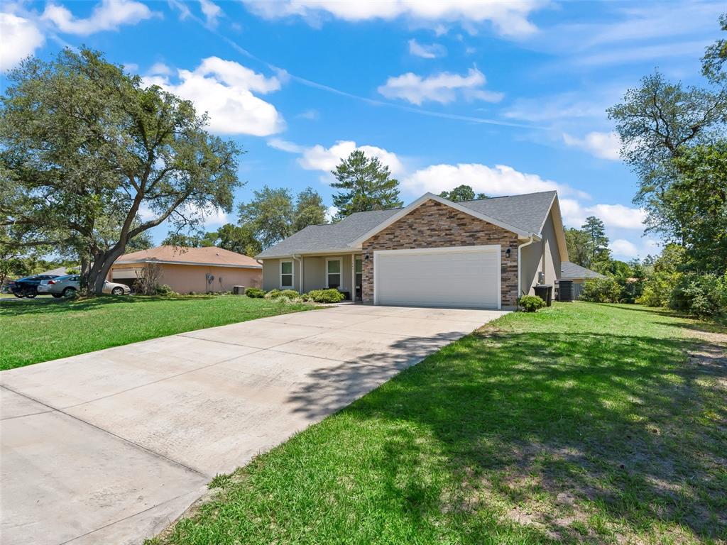 A single-story house with a stone facade, a two-car garage, and a concrete driveway — 13645 SW 39TH COURT, OCALA, FL