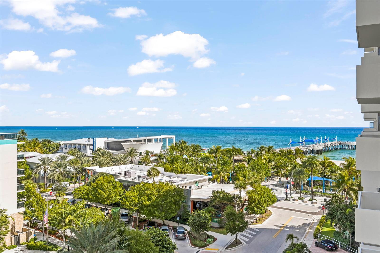 An elevated view shows a coastal area with palm trees, buildings, and a fishing pier — 133 N Pompano Beach Boulevard # 702, Pompano Beach FL 33062, POMPANO BEACH, FL