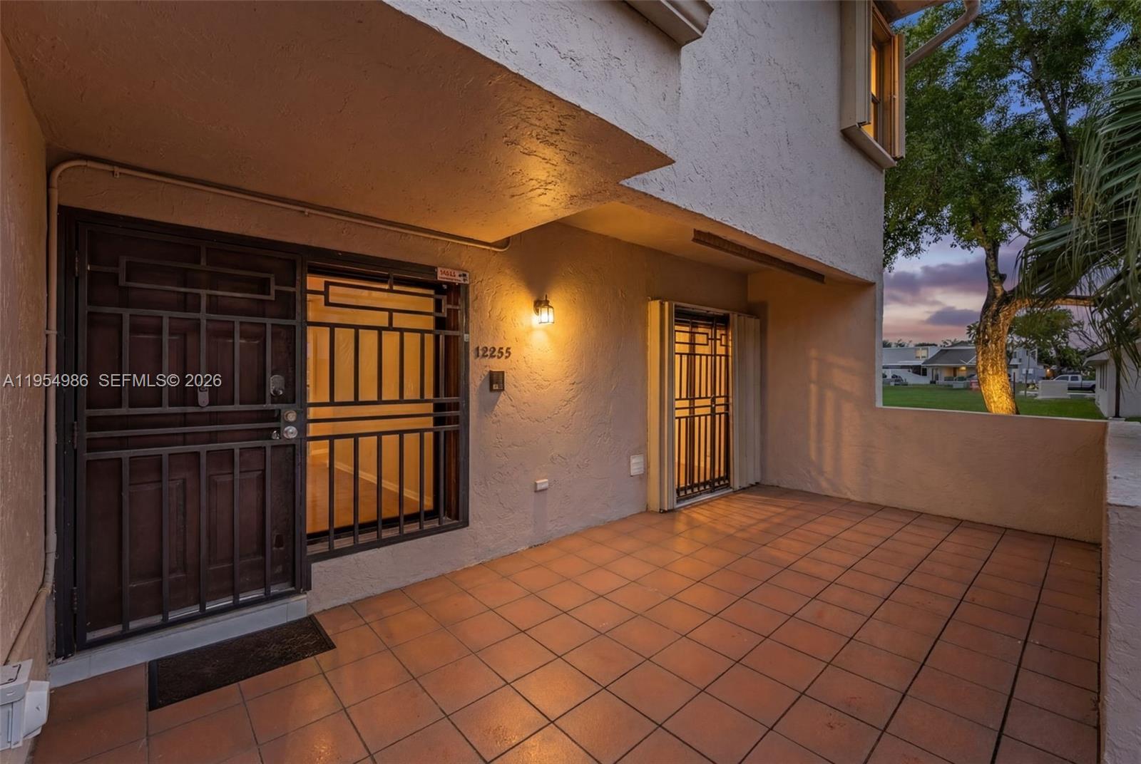 A tiled patio features a front door and a sliding glass door with security grilles — 12233 SW 24th Ter # 35, Miami FL 33175, MIAMI, FL