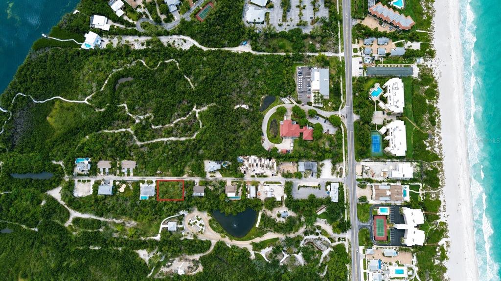 This aerial view shows a coastal residential area with a highlighted vacant lot — 561 GULF BAY ROAD, LONGBOAT KEY, FL