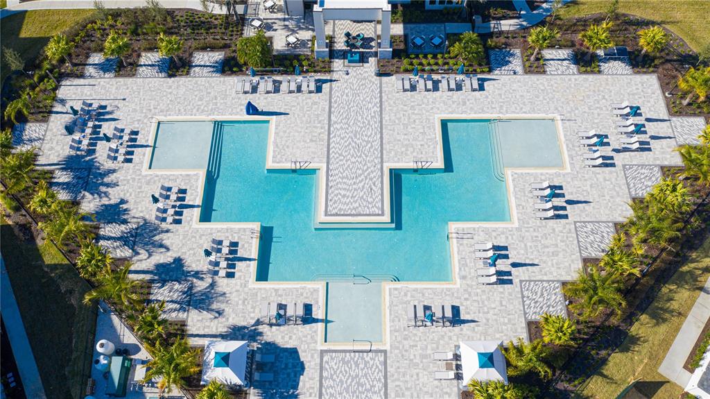 An aerial view shows a large swimming pool with lounge chairs on a paved deck — 7740 SANDY RIDGE DRIVE UNIT 231, KISSIMMEE, FL