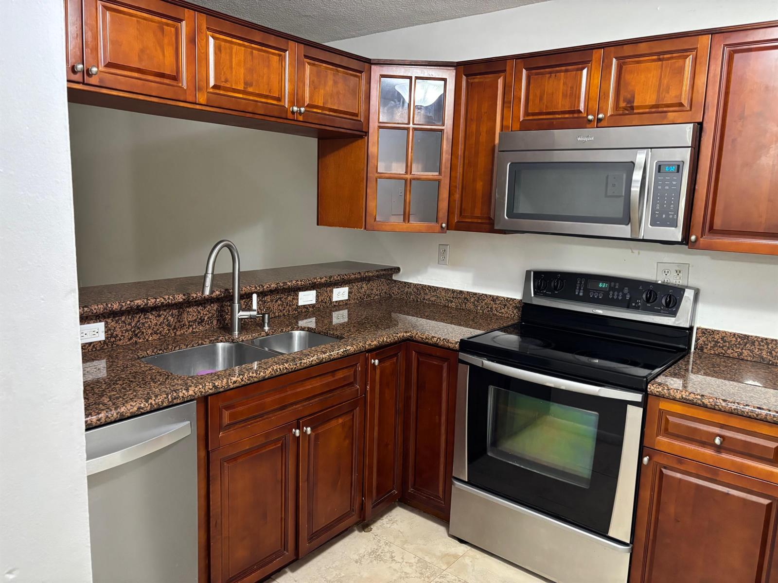 A kitchen features wood cabinets, granite countertops, and stainless steel appliances — 9959 Nob Hill Place, Sunrise FL 33351, SUNRISE, FL