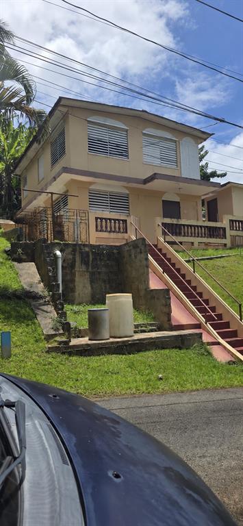 A two-story tan house with louvered windows and an exterior staircase leading to the entrance — 53 Aquilino CARR. 430, BO. OVEJAS, ANASCO, PR