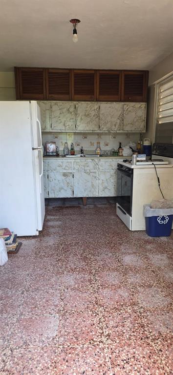 A kitchen features marble-patterned cabinets, wood-slatted upper storage, a white refrigerator, and terrazzo flooring — 53 Aquilino CARR. 430, BO. OVEJAS, ANASCO, PR