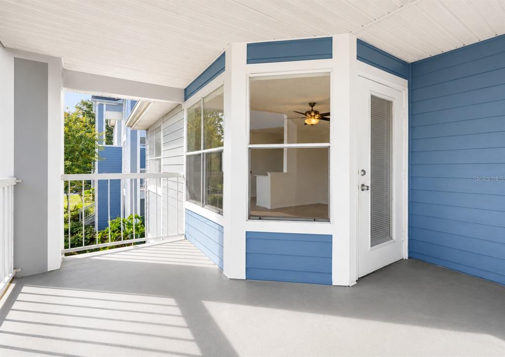 A covered balcony with blue siding, a white railing, and a glass door — 2585 GRASSY POINT DRIVE UNIT 211, LAKE MARY, FL
