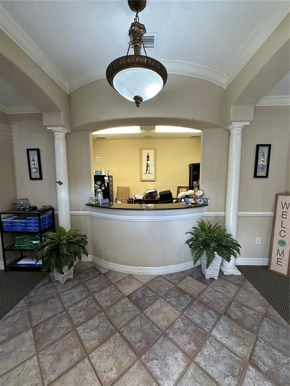 A reception area features a curved desk, two white columns, and a hanging pendant light — 8345 GUNN HIGHWAY, TAMPA, FL