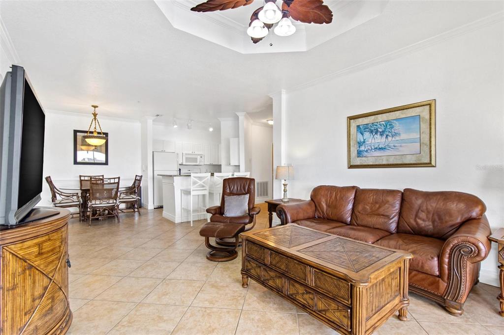 A living room with a brown leather sofa, matching recliner, and tile flooring — 2739 VIA CAPRI UNIT 1039, CLEARWATER, FL