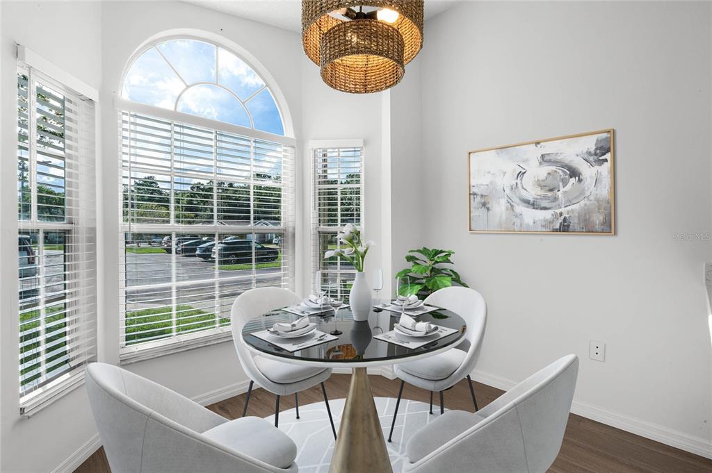 A bright dining nook features a round table, four chairs, and a large arched window — 239 PANORAMA DRIVE, WINTER SPRINGS, FL