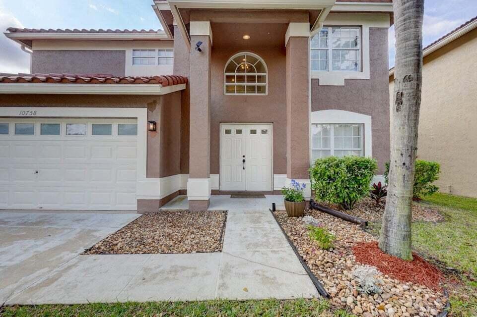 A two-story house with a brown stucco exterior, white trim, and a double front door — 10758 Lake Jasmine Drive, Boca Raton FL 33498, BOCA RATON, FL