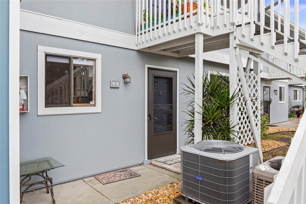 A kitchen with white cabinets and a stone island overlooks an open living area — 6033 34TH STREET W UNIT 83, BRADENTON, FL