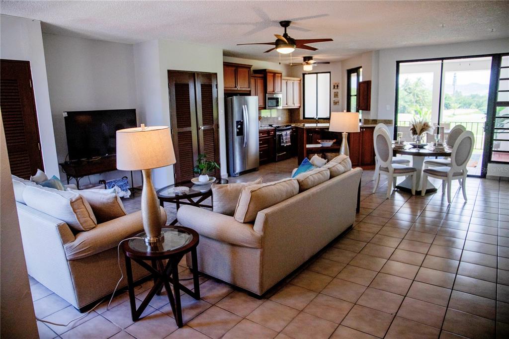 An open-concept living and dining area features tile flooring, a kitchen, and a balcony view — 185 CANDELERO DRIVE UNIT 671, HUMACAO, PR