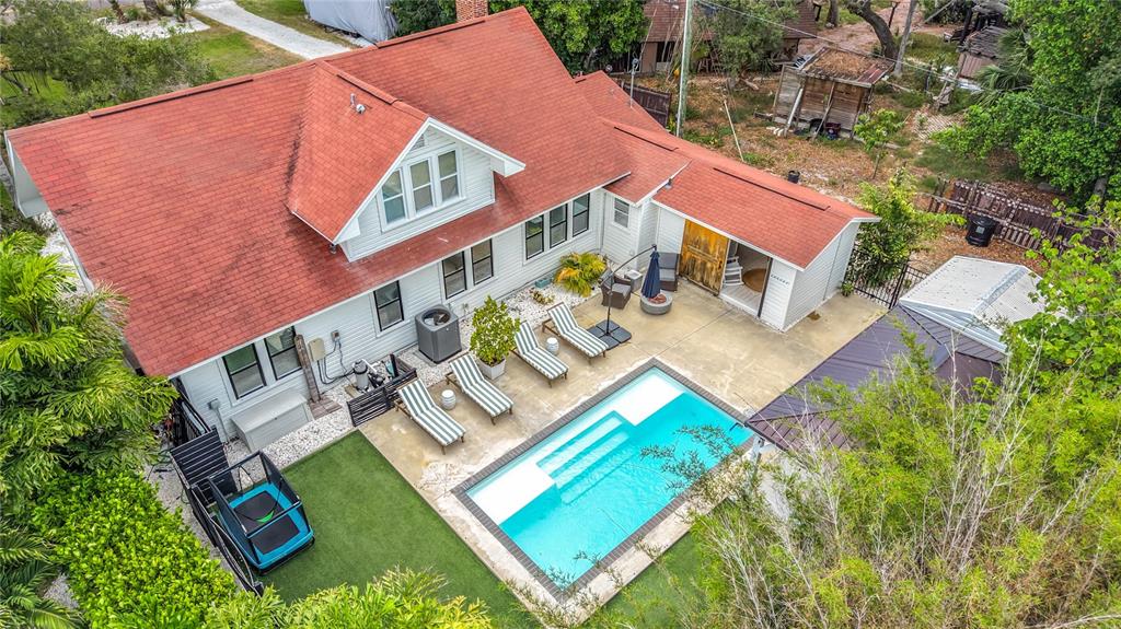 An aerial view shows a house with a red roof, a swimming pool, and patio — 675 S VINCENT STREET, CRYSTAL BEACH, FL