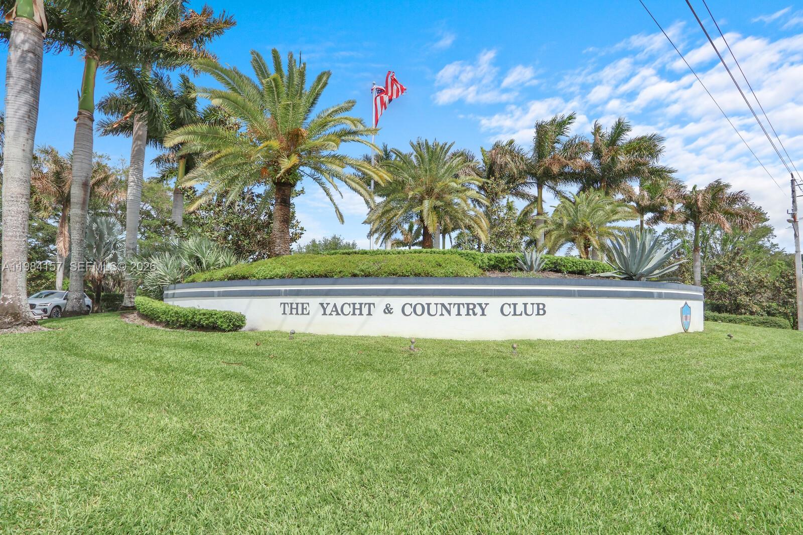 A curved stone sign for The Yacht & Country Club sits amidst palm trees — 3482 SE Court Dr, Stuart FL 34997, STUART, FL