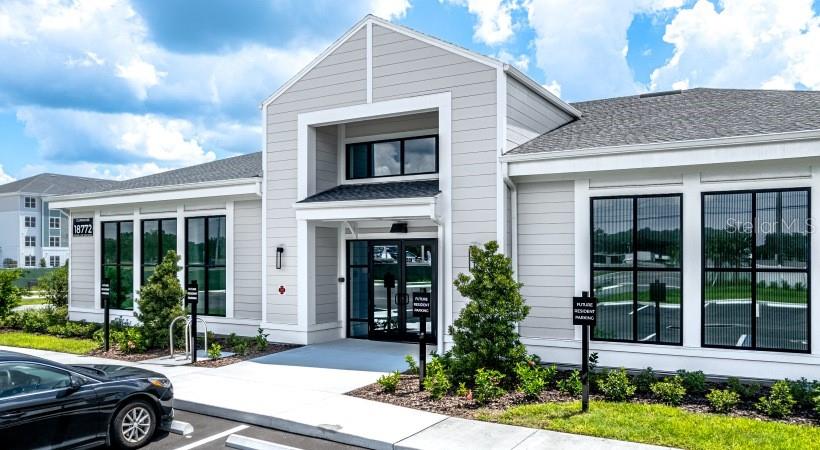The exterior of a light gray building features large windows and a central glass entrance — 18772 GRAND LIVE OAK BOULEVARD UNIT A2.1, LAND O LAKES, FL