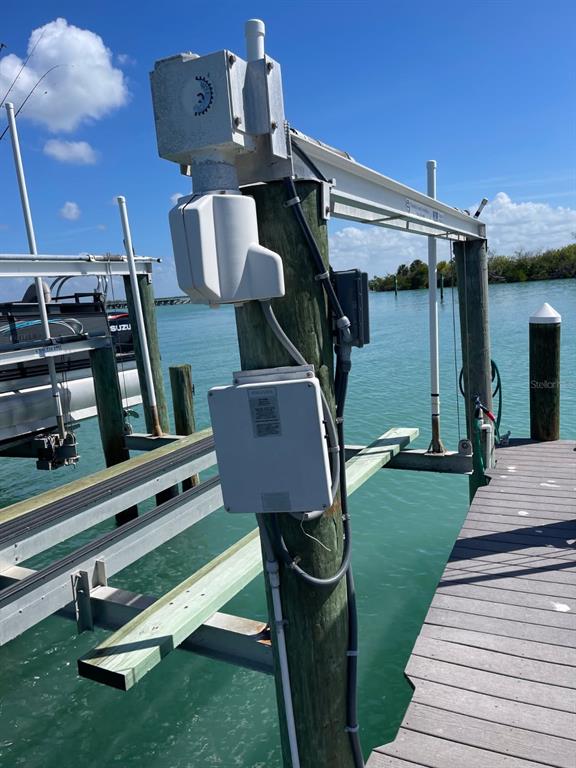 A boat lift mechanism is mounted on a wooden piling next to a wooden dock — 6020 BOCA GRANDE CAUSEWAY UNIT 43 Boat Slip, BOCA GRANDE, FL