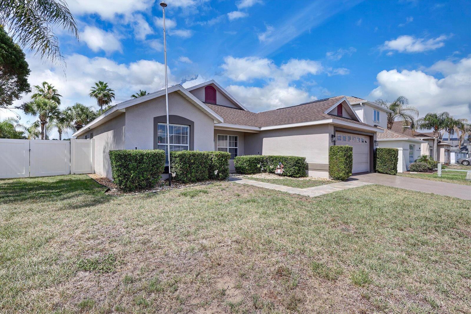 A single-story house with a beige stucco exterior, a garage, and a front lawn — 1175 Jaybee Avenue, Davenport FL 33897, DAVENPORT, FL