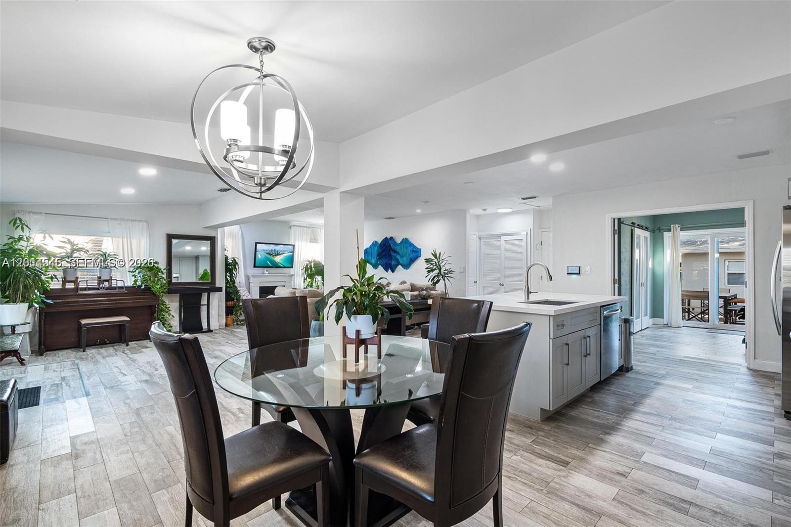 A dining area with a glass table sits adjacent to a modern kitchen — 1946 SW 20th St # 1946, Miami FL 33145, MIAMI, FL