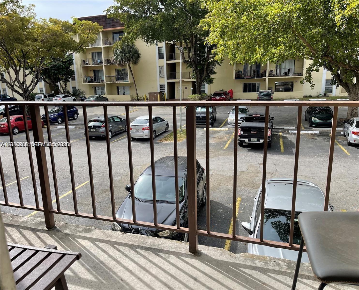 A view from a balcony overlooking a parking lot and a multi-story apartment building — 12035 NE 2nd Ave # A209, North Miami FL 33161, NORTH MIAMI, FL