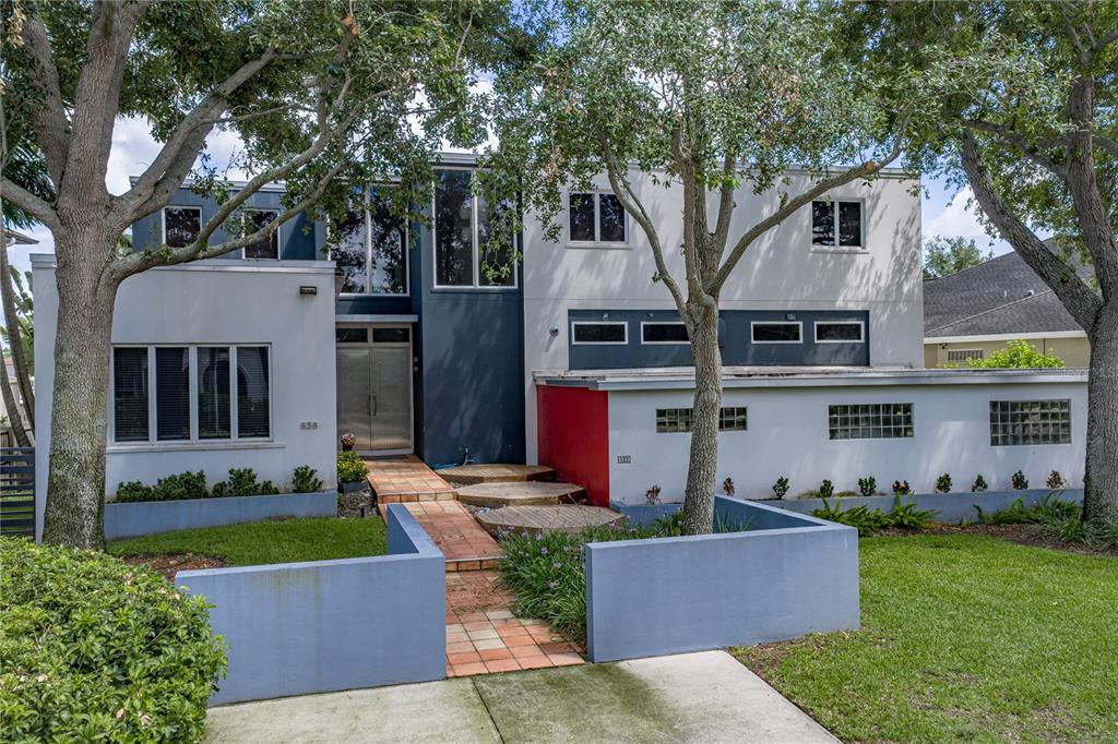 A dining room features a wooden table, six chairs, wall art, and glass doors to a patio — 838 MONTEREY BOULEVARD NE, ST PETERSBURG, FL