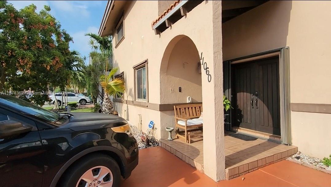 A black SUV is parked in front of a house with a covered porch entrance — 11060 SW 143rd Pl, Miami FL 33186, MIAMI, FL
