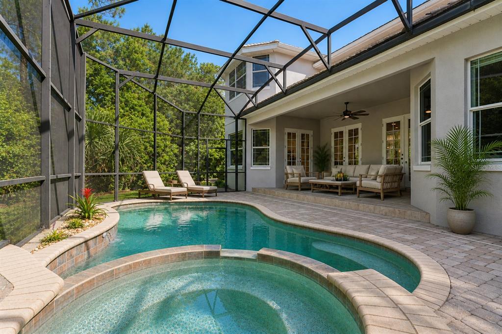 A modern open-concept living area features a kitchen island, curved sofa, and a staircase — 10370 TROUT ROAD, ORLANDO, FL