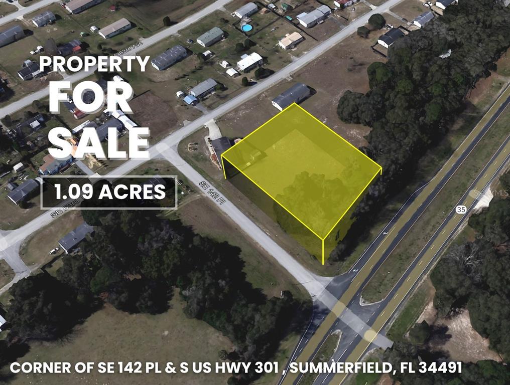An aerial view shows a wooded lot situated between a paved road and a highway — Corner SE 142ND PLACE & S US HWY-301, SUMMERFIELD, FL